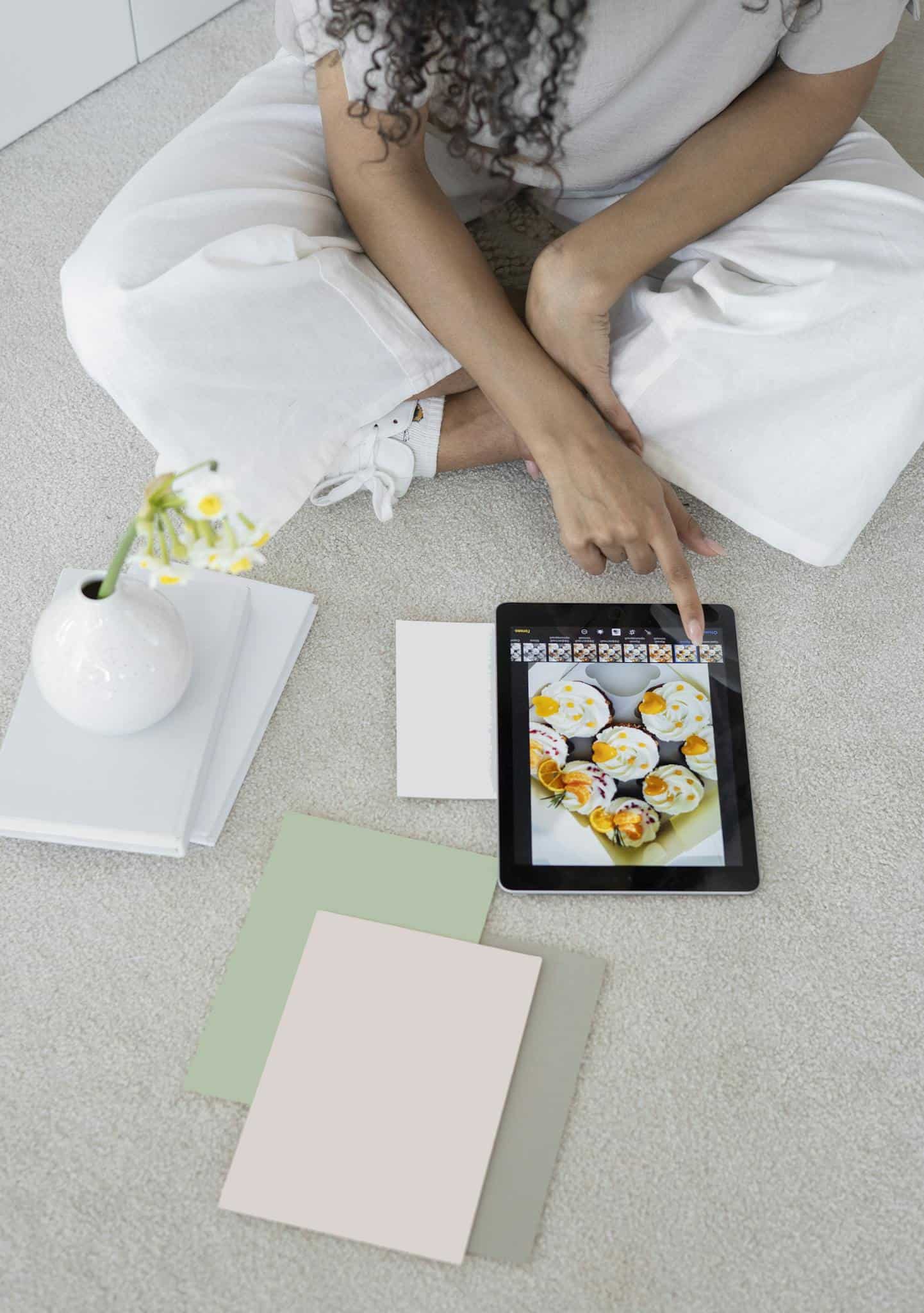 Young woman using a tablet in a modern, minimalist workspace with pastel decor.
